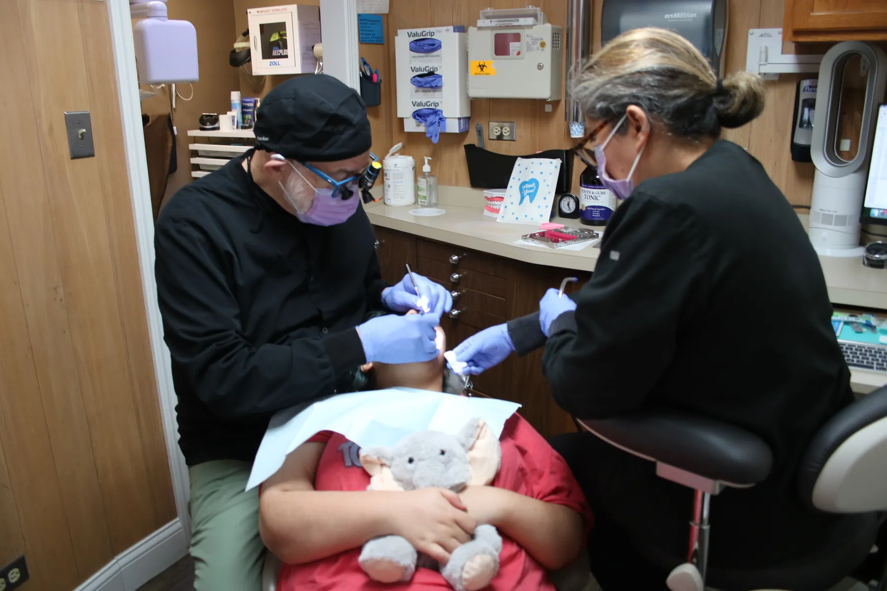 A patient holding a stuffed elephant during a dental appointment